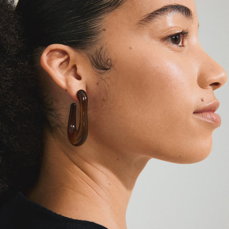 PILGRIM | ELIJAH RECYCLED BROWN EARRINGS - SILVER PLATED

Go with all your heart! The large, oval ELIJAH hoops from Pilgrim, in brown recycled acrylic, introduce an edgy retro vibe to your favourite AW styles. Perfect for those looking for a street-ready accessory and who cherish a classic urban look! Style the earrings with a chunky jumper and an oversized blazer for a laid-back elegance that transitions effortlessly from day-to-night