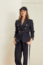 Load image into Gallery viewer, Introducing the new&nbsp; We are the others, Alba Pant in a rich indigo color, featuring a stylish contrast bone stripe down the side leg. Crafted from a comfy twill fabrication, these pants offer a relaxed fit and an elastic waist for ultimate comfort. Perfect for elevating your casual look or dressing up for a night out, the Alba Pant combines effortless style with everyday ease.
