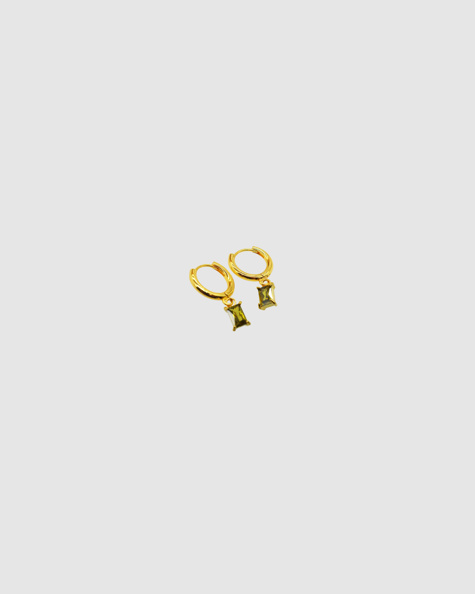 Arina Earrings by Castel & Co are gold-plated stainless steel hoop earrings featuring an olive green stone drop. Designed with a slim, elegant silhouette, they offer a lightweight feel (3g) and a Congo closure, measuring 2.2 x 0.4 cm. Crafted to catch the light with movement, they’re suitable for both everyday wear and evening styling. Hypoallergenic and waterproof.