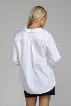 The distinguished Blak Atlas Shirt in crisp white combines every thing you need in a refined silhouette. Features include a v-neckline with collar, button-through front, and long sleeves culminating in deep cuffs with elegant tie closures. A discreet patch pocket adds functionality, while the back yoke with inverted box pleat ensures graceful movement. Sophisticated side-splits and a curved hemline complete this versatile piece, suitable for both professional and casual occasions.
Fabric composition -Cotton