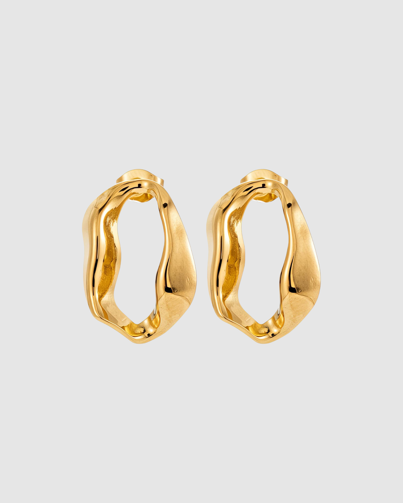 Aurora Earrings by Castel & Co are gold-plated stainless steel sculptural hoop earrings featuring a fluid, organic silhouette. Designed with a modern, artistic shape that balances statement appeal with everyday wearability, they are lightweight (3g) with a stud closure and measure 2.1 x 1.4 cm. Hypoallergenic and waterproof.