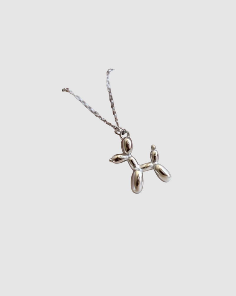 Balloon Dog Necklace by Castel & Co in radiant gold plating, featuring a playful sculptural pendant inspired by a balloon dog design. Suspended on a fine chain for a modern, whimsical statement that can be worn solo or layered. Lobster claw closure with a 40 + 5 cm adjustable length. Crafted from stainless steel, waterproof, hypoallergenic, and weighing 12g.