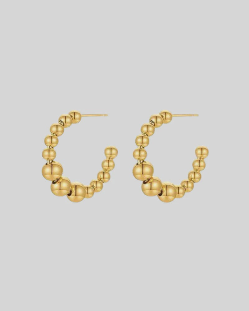 CASTEL & CO
The Bubble Hoops are a playful yet sophisticated take on the classic hoop earring, featuring smooth, rounded details that add texture and dimension to any look. Their gold-plated finish makes them effortlessly versatile, whether you’re dressing up or down.
Main material: gold plating, stainless steel
Closure type: stud
Waterproof and hypoallergenic
Weight: 8g