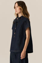 Made from our favourite cotton denim, the POL Carsen Denim Shirt is a new short sleeved style perfect for Spring.

-Slip on style.
-Stand Collar.
-Contrast button closure through to the waist.
-Dropped armholes create a cap sleeve.
-Oversized fit