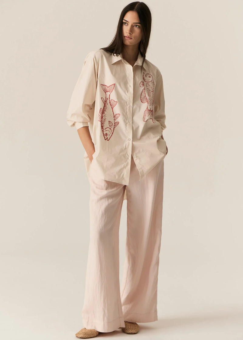 POL CASSIS FISH SHIRT
-Classic shirt collar.
-Button closure through the centre front.
-Gathered detail from yoke at the centre back.
-In-house designed placement fish print on either side at the front.
-Full length sleeves.
-Gathers at the cuffs - two button closure.
-Oversized fit through the body - longline silhouette.
-Hem curves down at the centre back.
-A-line shape.
-Available in Denim/Pebble and Natural/Berry.
100% COTTON