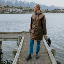 Charlie by Moke lightweight women’s raincoat in Antique Gold, featuring a sleek, streamlined silhouette and soft touch matte TPU finish with 5,000mm waterproof rated fabric, designed for easy layering and everyday wear in light to moderate rain.