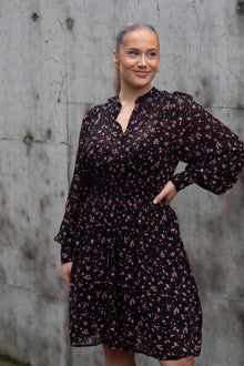 MSCH Evelda dress is a feminine and floral dress, in a viscose lightweight outer layer with a black pettycoat. The dress features a long sleeve with a wide cuff, a simple round neckline and an elastic at the waist. There are small buttons at the front of the dress, allowing you to choose whether you want it more open at the chest or fully closed.

Fitting
This dress has a regular fit. The model is 173cm and wears a size S.

Composition
100% Viscose