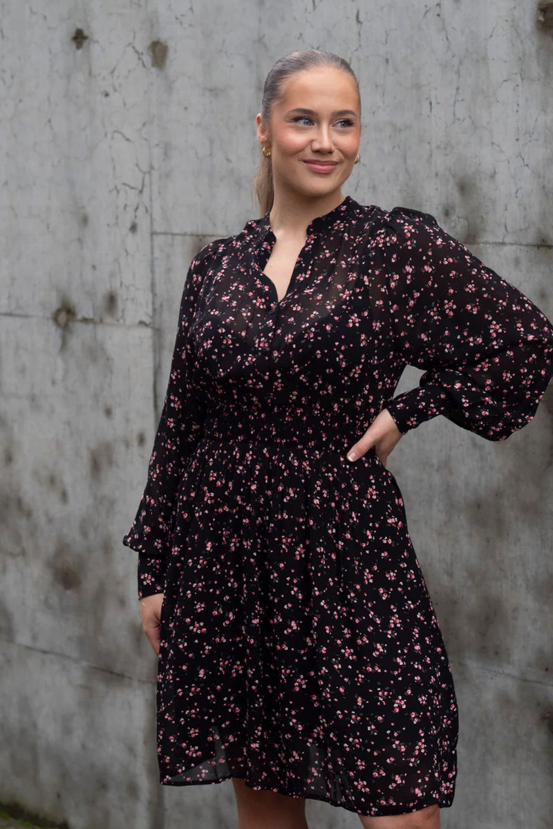 MSCH Evelda dress is a feminine and floral dress, in a viscose lightweight outer layer with a black pettycoat. The dress features a long sleeve with a wide cuff, a simple round neckline and an elastic at the waist. There are small buttons at the front of the dress, allowing you to choose whether you want it more open at the chest or fully closed.

Fitting
This dress has a regular fit. The model is 173cm and wears a size S.

Composition
100% Viscose