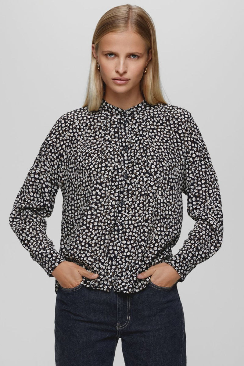 The MSCH Zeida shirt is crafted from a beautiful black fabric with a delicate white floral print. Featuring long sleeves, a small collar, and cuffs, it's the perfect everyday shirt thanks to its lightweight and comfortable design. Style it with black for a complete autumn look, or pair it with your favorite skirt to brighten up your outfit.