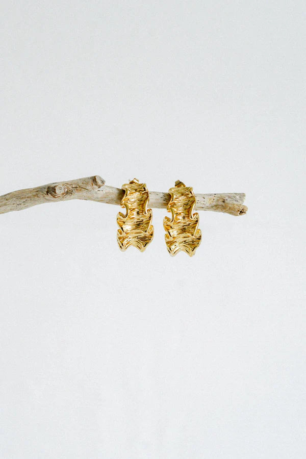 Textured, bold, and effortlessly chic—the Castel & Co Crinkle Earrings in Gold bring a sculptural edge to classic jewellery. Their organic, rippled design reflects light beautifully, creating a statement that feels both modern and timeless. Perfect for adding depth to minimal looks or enhancing an already bold ensemble, these earrings offer a sophisticated yet playful finish to any outfit.

Main material: gold plating, stainless steel
Closure type: stud
Earrings size: 3 x 1,5 cm
Waterproof/ hypoallergenic
