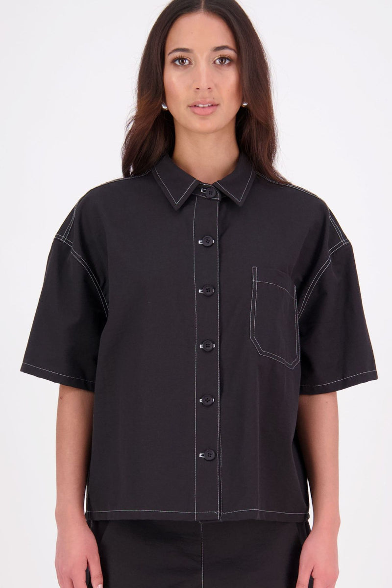 The N-E-S Demi Shirt is your ultimate summer must-have, blending a utilitarian edge with everyday versatility. Designed as a short-sleeve, boxy-fit shacket, it features a button-down front, single breast pocket, and elbow-length sleeves. Wear it open or closed—perfect for layering or styling solo through the warmer months.

Our model is 174cm and wear a XS/S (8-10)

Composition: Kale pop - cotton twill | Black - cotton, nylon

Designed and Made in New Zealand