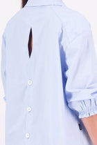 The N-E-S Fara Shirt blends classic tailoring with soft, modern touches. Featuring 7/8 sleeves with three layers of shirring at the cuffs, a traditional collar flowing into an open V-neck and centre front pleat. The drop-back design reveals a cross-over keyhole and centre back button detail. Style the sleeves your way—worn down, ruched up, or tucked under—for versatile, effortless dressing.
Composition: Sky (fine seersucker) - cotton, spandex | Oyster grey stripe cotton, polyamide, elastine.