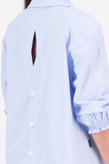 The N-E-S Fara Shirt blends classic tailoring with soft, modern touches. Featuring 7/8 sleeves with three layers of shirring at the cuffs, a traditional collar flowing into an open V-neck and centre front pleat. The drop-back design reveals a cross-over keyhole and centre back button detail. Style the sleeves your way—worn down, ruched up, or tucked under—for versatile, effortless dressing.
Composition: Sky (fine seersucker) - cotton, spandex | Oyster grey stripe cotton, polyamide, elastine.