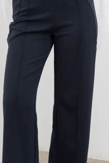 The NES Ginnie Pant is a stylish update to our top-selling Gin Pants, now featuring a pin stitch pleat down the front legs for an elongated, flattering silhouette. With a classic cut that’s easy to dress up or down, these pants are perfect for both work and everyday wear. The centre leg pin stitch detailing adds a touch of sophistication, while the flat front and covered elasticated back provide a comfortable, secure fit. The flattering angled panel at the front enhances the shape, and the full-length strai