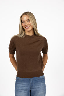Humidity Lifestyle Aurora Top in chocolate and deep sea, crafted from a lightweight knit with a soft drape, high neckline, and relaxed short sleeves. Features ribbed cuffs and hem for subtle structure, creating a versatile transeasonal style that can be worn loose or tucked, styled casually with denim, or dressed up with tailored pieces.
