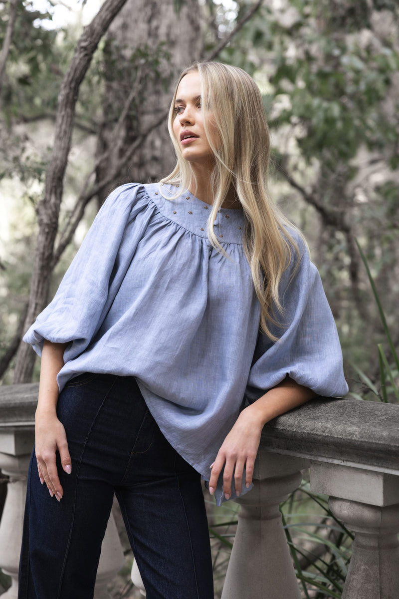 HUMIDITY LIFESTYLE - BAROQUE BLOUSE
A timeless piece with a touch of artisanal charm. This beautifully oversized blouse is crafted from 100% linen- breathable and natural. Designed with softly billowing sleeves and handcrafted bead detailing, it’s all about effortless elegance. This piece pairs just as beautifully with tailored pants as it does with your favourite denims.