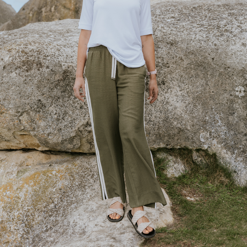 INDIANA BY MOKE
The Indiana Pants are back - and it’s no surprise they’re a top seller. Cut from a breathable viscose-nylon blend, these wide-leg pants are designed for comfort, polish, and all-day wear.
Cream contrast stripes run down each leg for a sport-luxe edge, while subtle side splits at the hem add movement and a touch of ease. The fit is streamlined yet relaxed, with a wide-leg silhouette that flatters every shape and pairs beautifully with tanks, tees, or a crisp shirt.