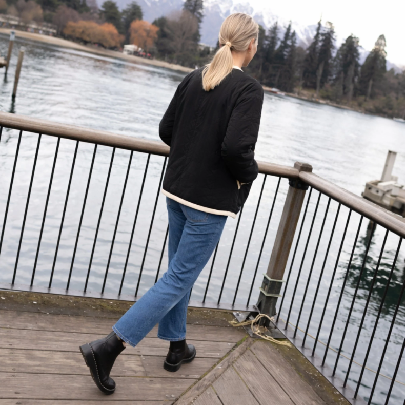 Juniper by Moke women’s reversible winter jacket with two distinct looks. One side features a clean silhouette with contrast piping for a refined everyday finish, while the reverse reveals plush faux shearling with soft pile texture for added warmth and a cosy statement feel. Designed for effortless layering, this thicker winter essential offers a relaxed yet polished fit, versatile styling, and is thoughtfully designed in New Zealand.