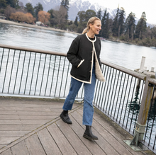 Juniper by Moke women’s reversible winter jacket with two distinct looks. One side features a clean silhouette with contrast piping for a refined everyday finish, while the reverse reveals plush faux shearling with soft pile texture for added warmth and a cosy statement feel. Designed for effortless layering, this thicker winter essential offers a relaxed yet polished fit, versatile styling, and is thoughtfully designed in New Zealand.