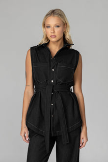 The BLAK Kent Vest offers quality cotton denim with traditional white topstitching in a comfortable relaxed fit. Features include easy-to-use dome closures, a flattering collar, and practical front pockets for your essentials. The included tie belt helps create your ideal silhouette, while the thoughtfully designed back with inverted pleat ensures both comfort and movement. 
