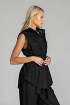 The BLAK Kent Vest offers quality cotton denim with traditional white topstitching in a comfortable relaxed fit. Features include easy-to-use dome closures, a flattering collar, and practical front pockets for your essentials. The included tie belt helps create your ideal silhouette, while the thoughtfully designed back with inverted pleat ensures both comfort and movement. 