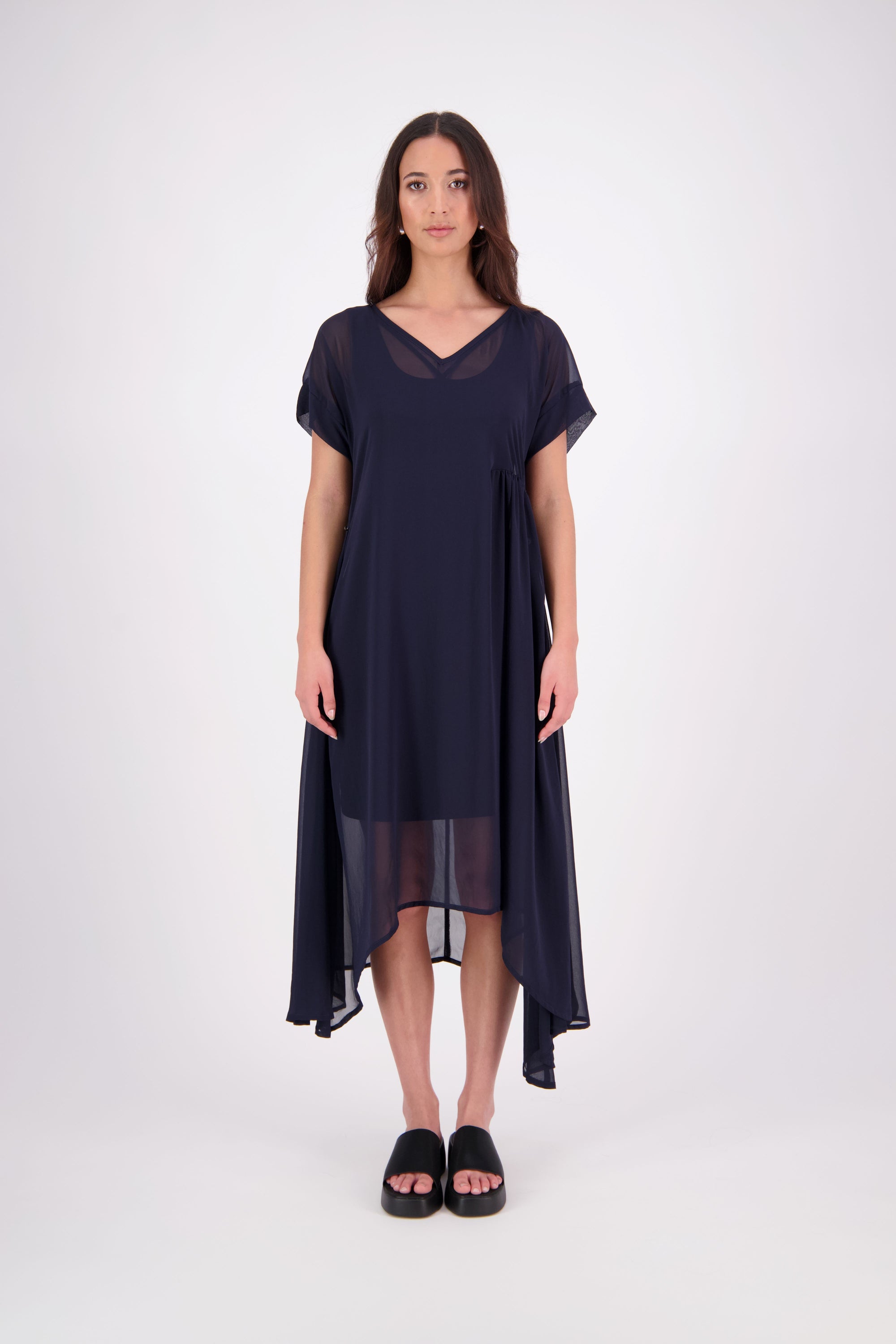 The NES Kira Dress blends the best of two favourites – the elegance of the Dreamliner and the versatility of the Flow Dress. With a relaxed drape and subtle tailoring, it features a flattering V-neckline, rouching under the bust on one side, cap sleeves, and adjustable button loop detailing for styling versatility (one dress - wear it 3 ways).