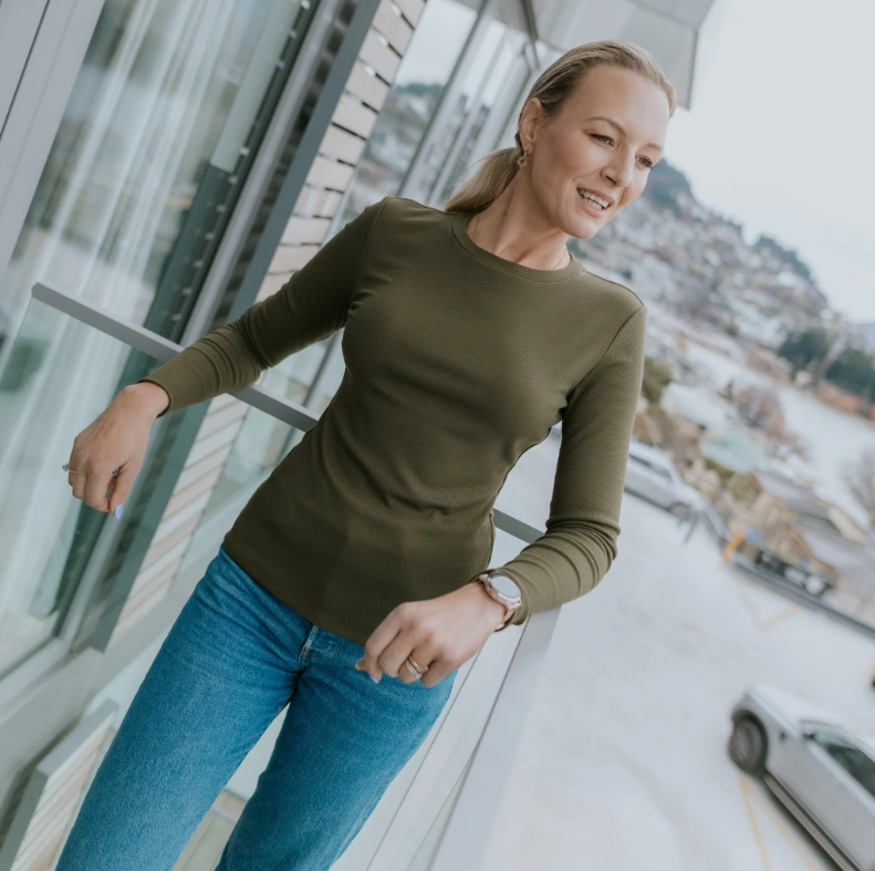 Lina by Moke women’s ribbed jersey top in a buttery soft double layered fabric for warmth, comfort, and confident coverage. Designed with a smooth, body skimming fit, round neckline, and long sleeves for effortless layering. Finished with subtle pale gold hardware at the back neck for a refined touch. An elevated everyday essential designed in New Zealand for polished, easy wear.