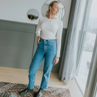 Lina by Moke women’s ribbed jersey top in a buttery soft double layered fabric for warmth, comfort, and confident coverage. Designed with a smooth, body skimming fit, round neckline, and long sleeves for effortless layering. Finished with subtle pale gold hardware at the back neck for a refined touch. An elevated everyday essential designed in New Zealand for polished, easy wear.