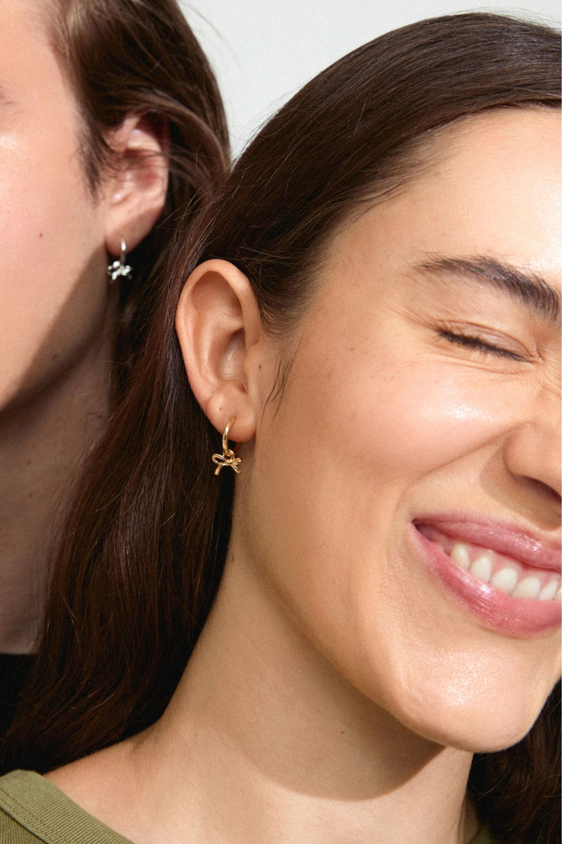 The bow earrings from Pilgrim's Classic collection. A set of small huggie hoops with tiny bow pendant.
Available in Gold-plated &amp; Silver-plated
Small bow pendants
Measures 18 mm in length
Summer must-have
Made from 99% recycled material
