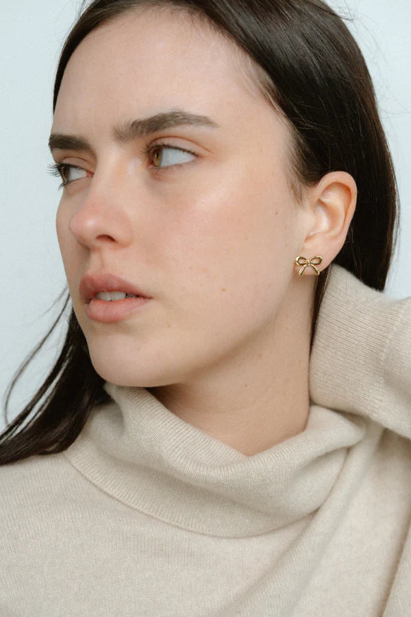 Polished and feminine, the Castel & Co Mini Bow Earrings in X-Small gold bring a bolder expression of the classic bow silhouette. With graceful curves and a radiant finish, they strike the perfect balance between statement and sophistication.

Material: Stainless steel, Gold plating
Closure Type: Stud
Earring Size: 20 mm
Waterproof and hypoallergenic
Weight: 1.5g