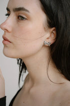 Refined yet playful, the Castel & Co Mini Bow Earrings in medium silver give the classic bow a modern edge. Their polished finish and graceful curves create subtle shine, offering a versatile stud that feels both feminine and contemporary.

Material: Stainless steel
Closure Type: Stud
Earring Size: 20 mm
Waterproof and hypoallergenic
Weight: 1.5g