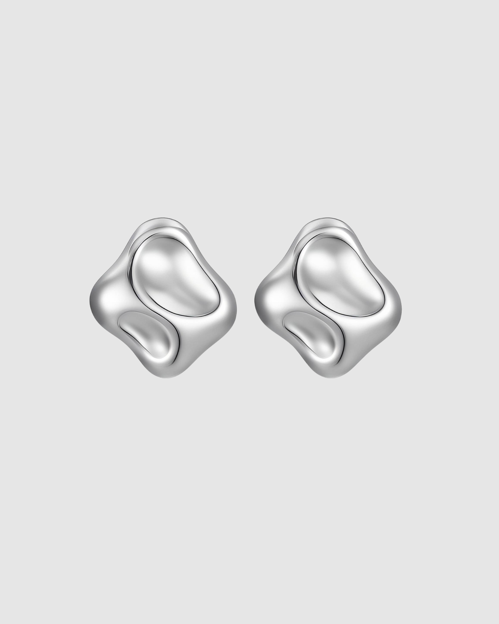 Molten Earrings by Castel and Co in polished silver, featuring sculptural, organic liquid-like curves that reflect light for a bold yet timeless statement. Stud closure with a 2 x 2 cm size, made from stainless steel, lightweight at 6g, waterproof and hypoallergenic.