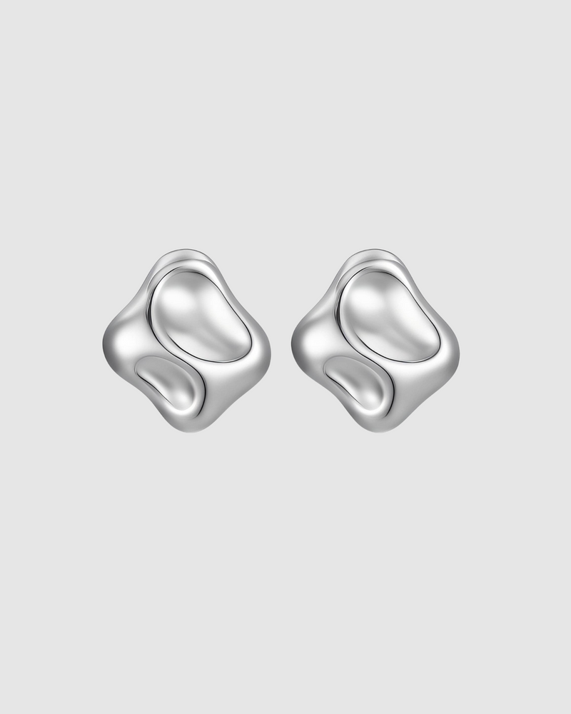 Molten Earrings by Castel and Co in polished silver, featuring sculptural, organic liquid-like curves that reflect light for a bold yet timeless statement. Stud closure with a 2 x 2 cm size, made from stainless steel, lightweight at 6g, waterproof and hypoallergenic.