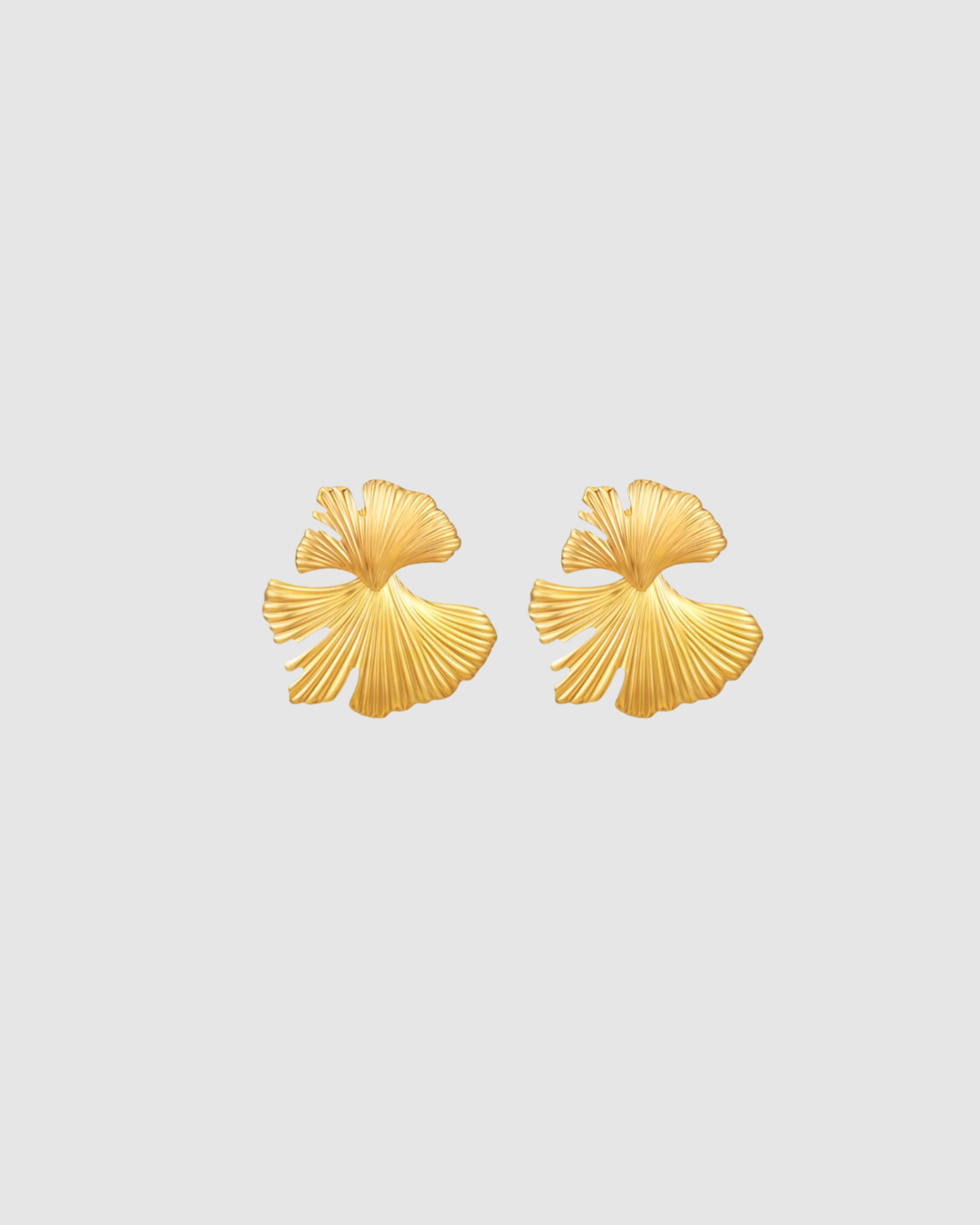 MUSE Earrings in warm gold with a sculptural, statement silhouette, designed to feel bold yet easy to wear. Stud closure with an oversized 8 x 8 x 2 cm form, crafted from stainless steel with gold plating. Waterproof, hypoallergenic, and lightweight for their size at 17g.