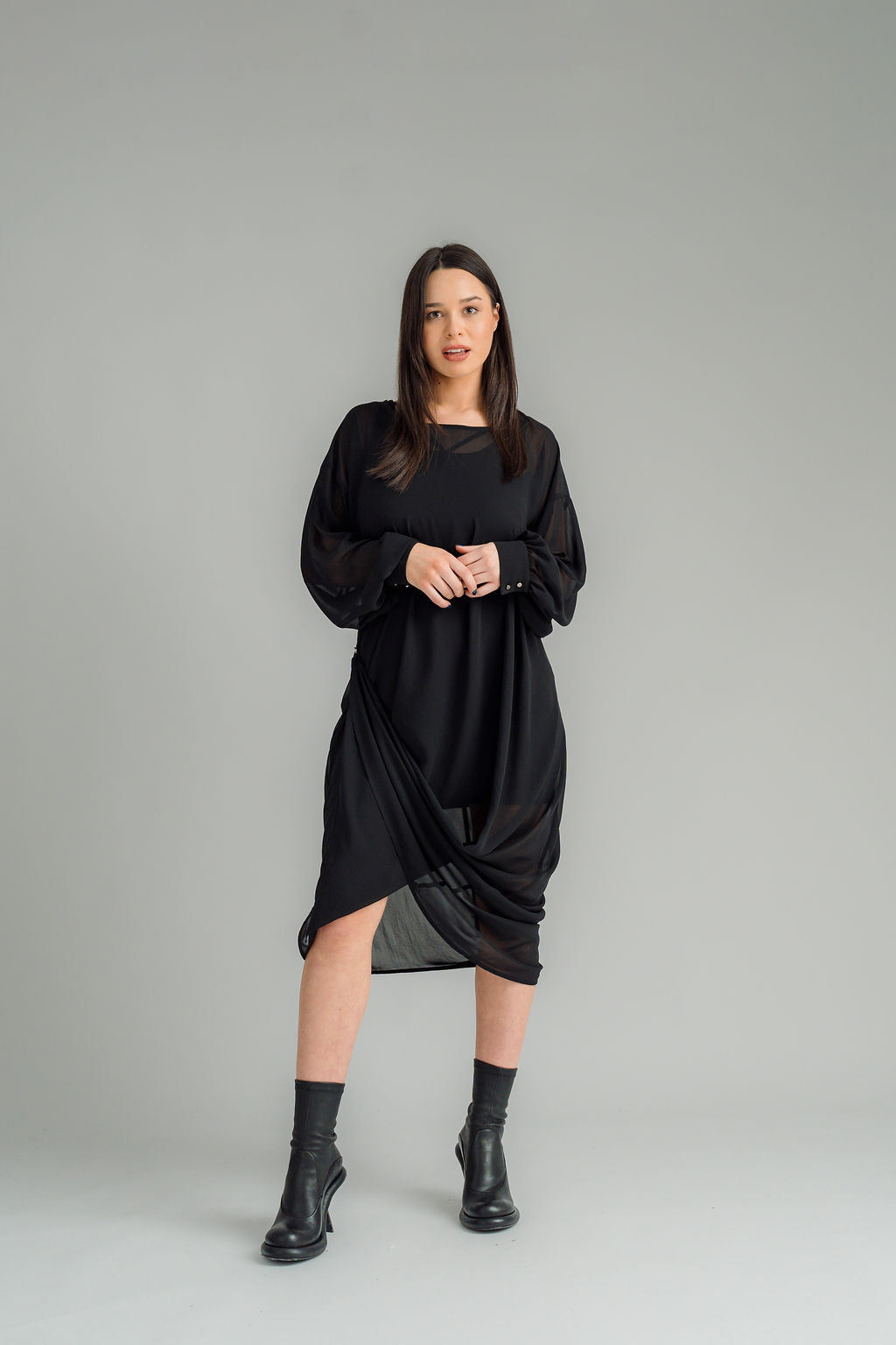 The NES Glide Dress is inspired by our best-selling NES Flow Dress, now with long sleeves for added warmth and versatility. This multi-seasonal dress is perfect for both casual and formal occasions, offering endless styling options. Wear it draped down the front for a relaxed look, or cinch it up at the side with the adjustable side button and hem loopers for a more defined shape. The long sleeves feature elasticated loopers and a metal shank cuff button for added detail. Style it with our Lattice Slip, sne