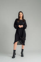 The NES Glide Dress is inspired by our best-selling NES Flow Dress, now with long sleeves for added warmth and versatility. This multi-seasonal dress is perfect for both casual and formal occasions, offering endless styling options. Wear it draped down the front for a relaxed look, or cinch it up at the side with the adjustable side button and hem loopers for a more defined shape. The long sleeves feature elasticated loopers and a metal shank cuff button for added detail. Style it with our Lattice Slip, sne
