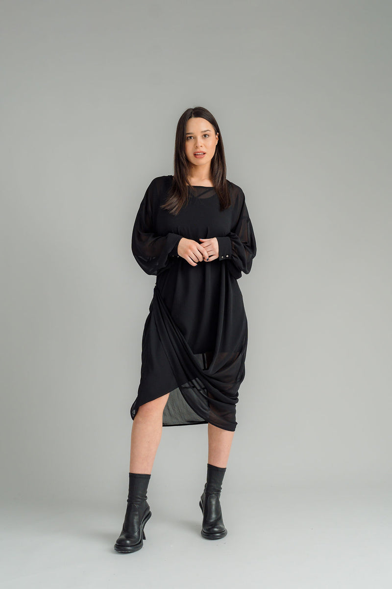 The NES Glide Dress is inspired by our best-selling NES Flow Dress, now with long sleeves for added warmth and versatility. This multi-seasonal dress is perfect for both casual and formal occasions, offering endless styling options. Wear it draped down the front for a relaxed look, or cinch it up at the side with the adjustable side button and hem loopers for a more defined shape. The long sleeves feature elasticated loopers and a metal shank cuff button for added detail. Style it with our Lattice Slip, sne