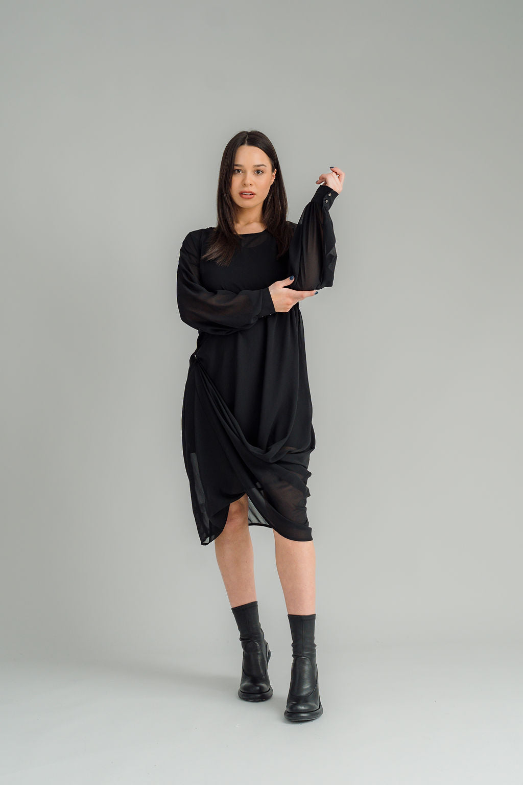 The NES Glide Dress is inspired by our best-selling NES Flow Dress, now with long sleeves for added warmth and versatility. This multi-seasonal dress is perfect for both casual and formal occasions, offering endless styling options. Wear it draped down the front for a relaxed look, or cinch it up at the side with the adjustable side button and hem loopers for a more defined shape. The long sleeves feature elasticated loopers and a metal shank cuff button for added detail. Style it with our Lattice Slip, sne
