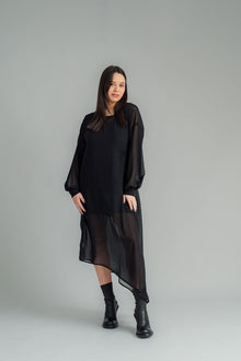 The NES Glide Dress is inspired by our best-selling NES Flow Dress, now with long sleeves for added warmth and versatility. This multi-seasonal dress is perfect for both casual and formal occasions, offering endless styling options. Wear it draped down the front for a relaxed look, or cinch it up at the side with the adjustable side button and hem loopers for a more defined shape. The long sleeves feature elasticated loopers and a metal shank cuff button for added detail. Style it with our Lattice Slip
