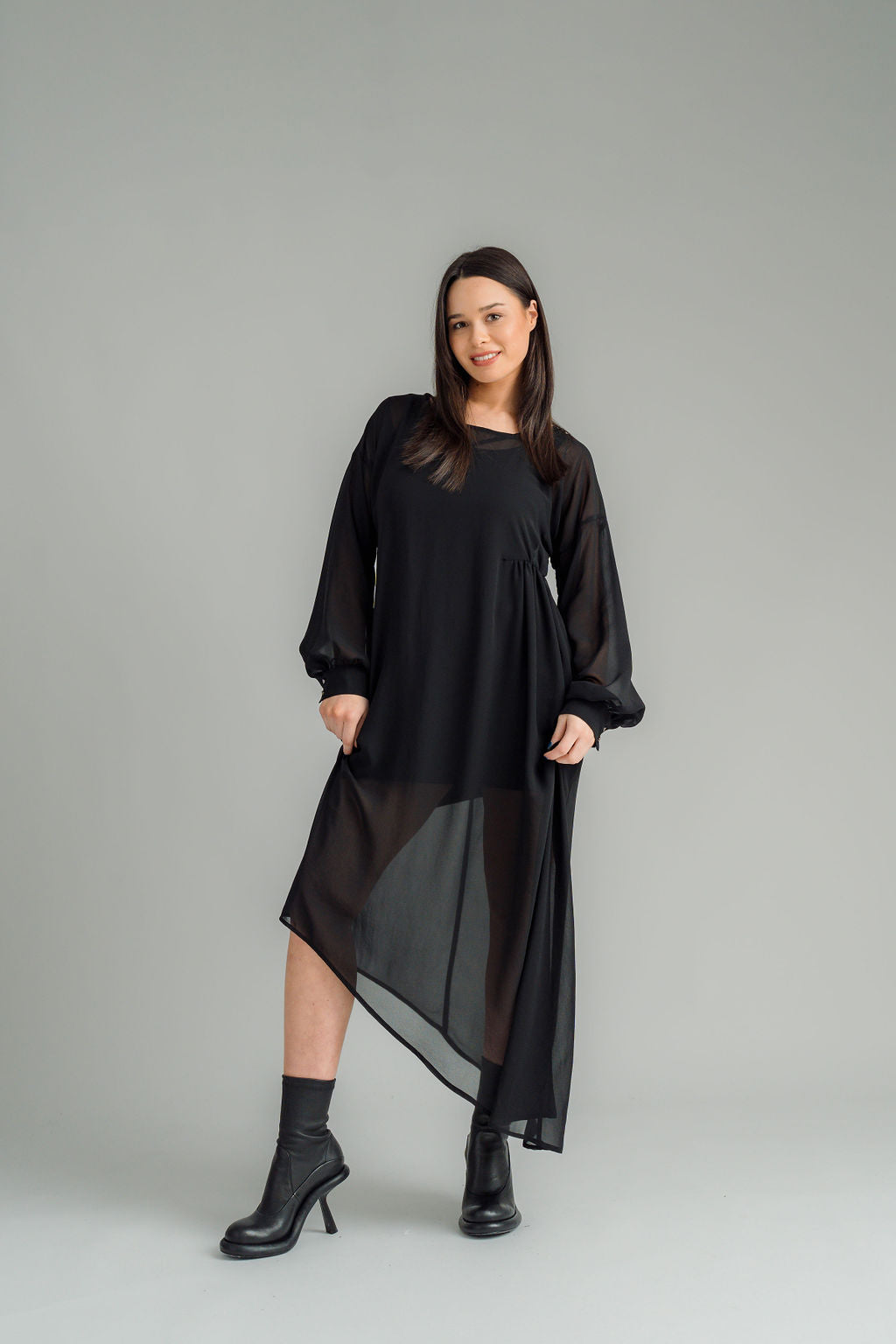 The NES Glide Dress is inspired by our best-selling NES Flow Dress, now with long sleeves for added warmth and versatility. This multi-seasonal dress is perfect for both casual and formal occasions, offering endless styling options. Wear it draped down the front for a relaxed look, or cinch it up at the side with the adjustable side button and hem loopers for a more defined shape. The long sleeves feature elasticated loopers and a metal shank cuff button for added detail. Style it with our Lattice Slip, sne