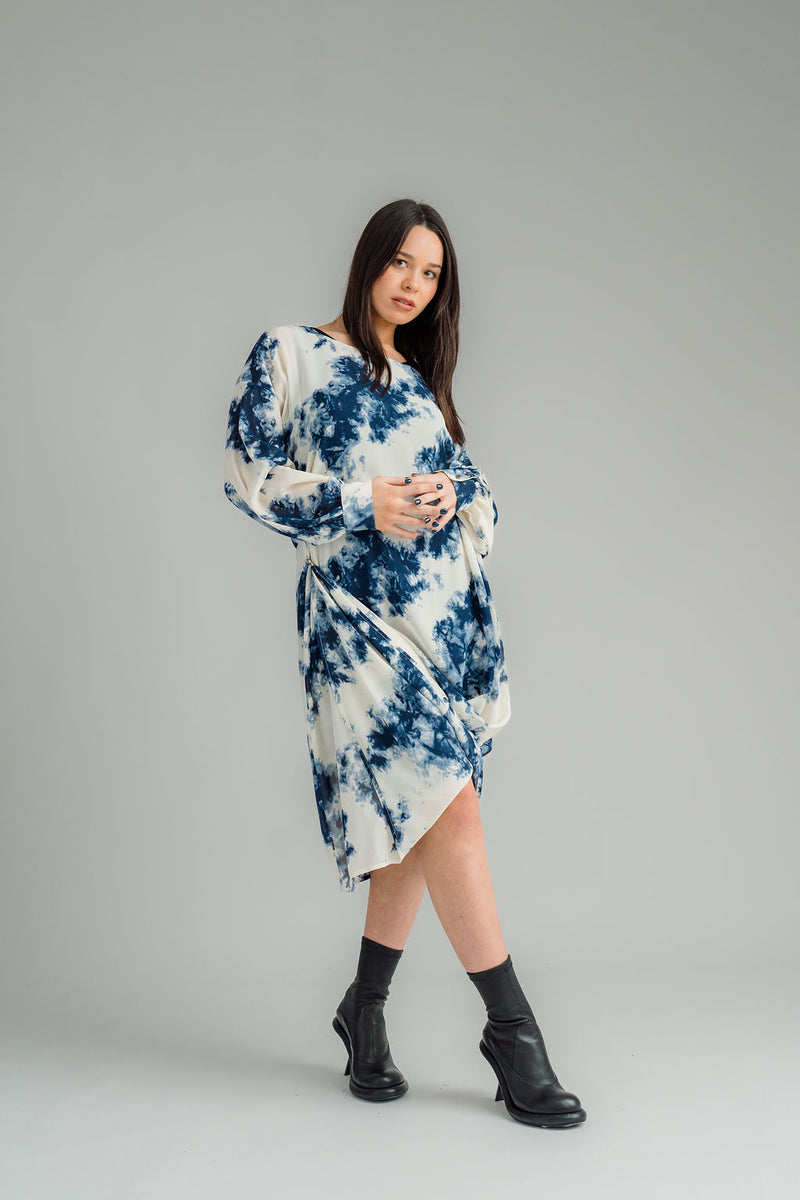 NES, Glide Dress. Flow dress but with long sleeves for added warmth and versatility. Multi-seasonal dress perfect for casual and formal occasions. Wear it draped down the front for a relaxed look, or cinch it up at the side with the adjustable side button and hem loopers for a more defined shape. The long sleeves feature elasticated loopers and a metal shank cuff button for added detail. Composition: viscose georgette