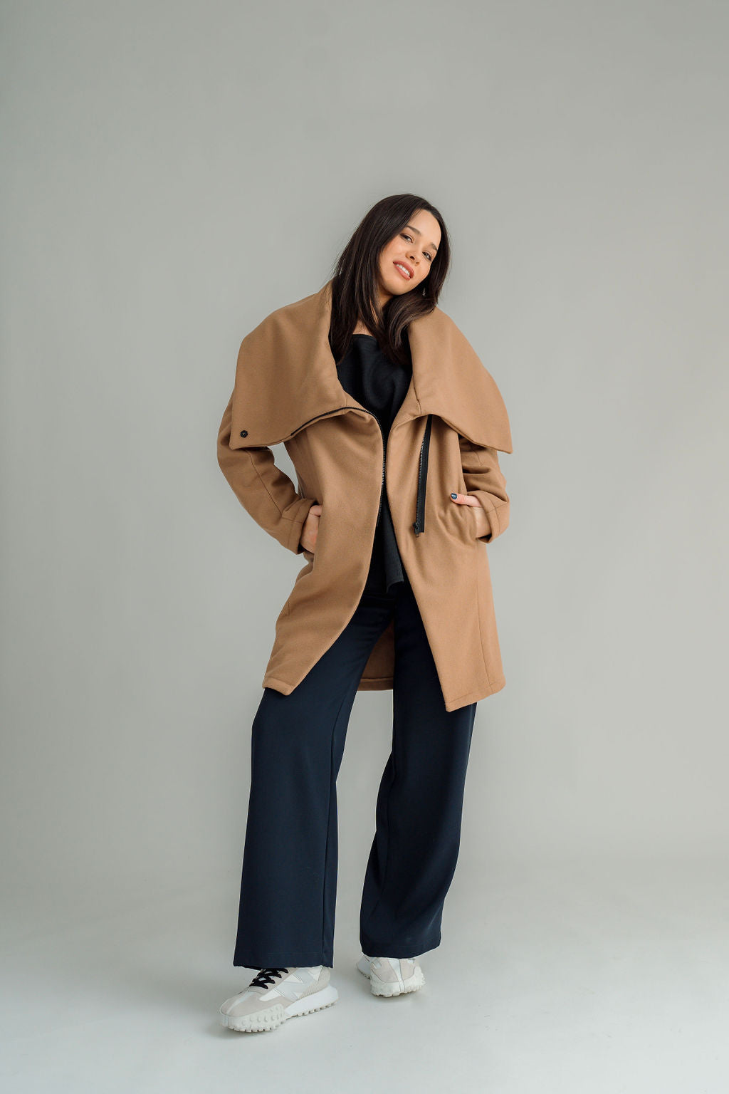 NES Tamara Coat – your ultimate winter companion, designed to elevate both style and comfort. Crafted from a luxurious wool-cashmere blend, this mid-thigh length coat offers the perfect balance of warmth and sophistication. The distinctive angled, exposed contrast black zip adds a modern edge, while the shawl collar gives you versatile styling options. Wear it up and secured with a snap dome for added warmth, or leave it open for a relaxed, draped look across your shoulders