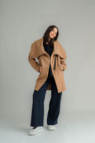 NES Tamara Coat – your ultimate winter companion, designed to elevate both style and comfort. Crafted from a luxurious wool-cashmere blend, this mid-thigh length coat offers the perfect balance of warmth and sophistication. The distinctive angled, exposed contrast black zip adds a modern edge, while the shawl collar gives you versatile styling options. Wear it up and secured with a snap dome for added warmth, or leave it open for a relaxed, draped look across your shoulders
