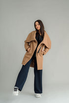 NES Tamara Coat – your ultimate winter companion, designed to elevate both style and comfort. Crafted from a luxurious wool-cashmere blend, this mid-thigh length coat offers the perfect balance of warmth and sophistication. The distinctive angled, exposed contrast black zip adds a modern edge, while the shawl collar gives you versatile styling options. Wear it up and secured with a snap dome for added warmth, or leave it open for a relaxed, draped look across your shoulders