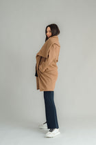 NES Tamara Coat – your ultimate winter companion, designed to elevate both style and comfort. Crafted from a luxurious wool-cashmere blend, this mid-thigh length coat offers the perfect balance of warmth and sophistication. The distinctive angled, exposed contrast black zip adds a modern edge, while the shawl collar gives you versatile styling options. Wear it up and secured with a snap dome for added warmth, or leave it open for a relaxed, draped look across your shoulders