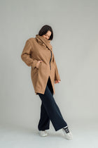 NES Tamara Coat – your ultimate winter companion, designed to elevate both style and comfort. Crafted from a luxurious wool-cashmere blend, this mid-thigh length coat offers the perfect balance of warmth and sophistication. The distinctive angled, exposed contrast black zip adds a modern edge, while the shawl collar gives you versatile styling options. Wear it up and secured with a snap dome for added warmth, or leave it open for a relaxed, draped look across your shoulders