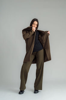 NES Tamara Coat – your ultimate winter companion, designed to elevate both style and comfort. Crafted from a luxurious wool-cashmere blend, this mid-thigh length coat offers the perfect balance of warmth and sophistication. The distinctive angled, exposed contrast black zip adds a modern edge, while the shawl collar gives you versatile styling options. Wear it up and secured with a snap dome for added warmth, or leave it open for a relaxed, draped look across your shoulders