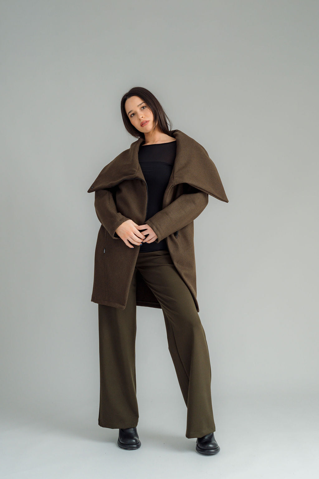 NES Tamara Coat – your ultimate winter companion, designed to elevate both style and comfort. Crafted from a luxurious wool-cashmere blend, this mid-thigh length coat offers the perfect balance of warmth and sophistication. The distinctive angled, exposed contrast black zip adds a modern edge, while the shawl collar gives you versatile styling options. Wear it up and secured with a snap dome for added warmth, or leave it open for a relaxed, draped look across your shoulders