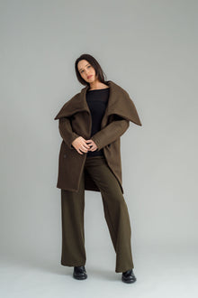 NES Tamara Coat – your ultimate winter companion, designed to elevate both style and comfort. Crafted from a luxurious wool-cashmere blend, this mid-thigh length coat offers the perfect balance of warmth and sophistication. The distinctive angled, exposed contrast black zip adds a modern edge, while the shawl collar gives you versatile styling options. Wear it up and secured with a snap dome for added warmth, or leave it open for a relaxed, draped look across your shoulders