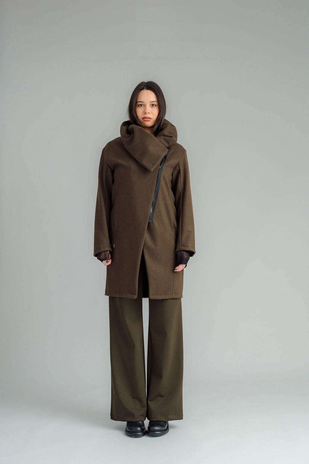 NES Tamara Coat – your ultimate winter companion, designed to elevate both style and comfort. Crafted from a luxurious wool-cashmere blend, this mid-thigh length coat offers the perfect balance of warmth and sophistication. The distinctive angled, exposed contrast black zip adds a modern edge, while the shawl collar gives you versatile styling options. Wear it up and secured with a snap dome for added warmth, or leave it open for a relaxed, draped look across your shoulders